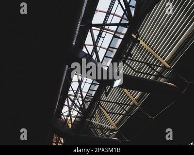 The roof of a hangar, a production hall or a sports hall. Metal structures, beams, supporting elements. Ventilation systems in large halls and rooms. Stock Photo