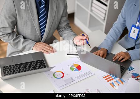 Professional male boss working with his financial team in the meeting, analyzing business financial data and planing a financial plan together. croppe Stock Photo
