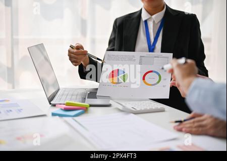 Cropped image of a professional female marketing worker presenting her marketing project ideas and explaining details on a report to her team in the m Stock Photo