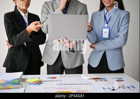 Cropped image of professional Asian businesspeople standing in front of the meeting, presenting or pitching their project to board members. Stock Photo