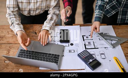 Cropped image of smart and professional engineers are discussing, brainstorming, measuring and checking building layout on a blueprint together in the Stock Photo