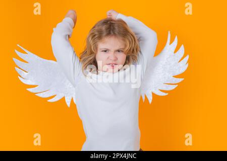 Valentine angel. Little cupid child. Kid angel with angels wings, isolated on yellow studio background. Valentines day gift card. Stock Photo