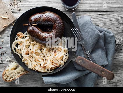 Bloody sausage morcilla and stewed sour turnip close up. Traditional Slovenian dish with roasted bloody sausage Stock Photo