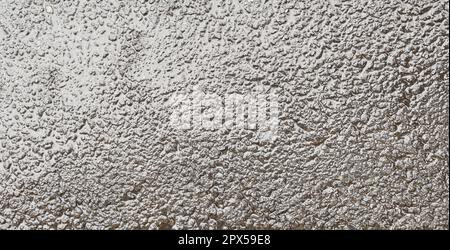 wet asphalt rough bitumen after rain tarmac road texture pavement surface background closeup top view Stock Photo