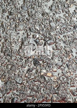 wet asphalt rough bitumen after rain tarmac road texture pavement surface background closeup top view Stock Photo