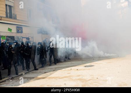 Paris, France. 27th Jan, 2023. Police officers, stand with their shields amid teargas smoke thrown at them by protesters during a demonstration in Nation square. Demonstrations over the increase in the retirement age (from 62 to 64) continue today on the occasion of May Day (International Labours Day) in Paris, which have turned into clashes between protesters and police. (Photo by Marco Cordone/SOPA Images/Sipa USA) Credit: Sipa USA/Alamy Live News Stock Photo