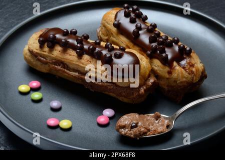 Two chocolate eclairs on a plate, eclair Stock Photo