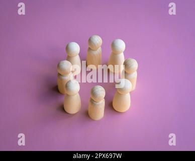 Wooden dolls standing in a circle facing each other. Team decision or working together concept. Stock Photo