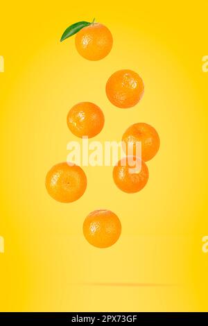 Falling mandarin fruits. Seven flying whole tangerines on colored table with clipping path as package design element and advertising. Full depth of fi Stock Photo