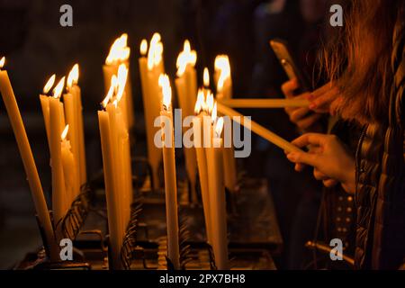 People light candles in a church in Venice Stock Photo