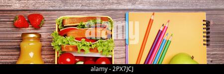 School meal. Lunch box with healthy food and different stationery on wooden table, flat lay. Banner design Stock Photo