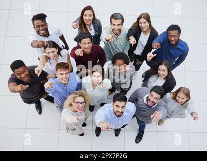 large team of young people pointing somewhere up Stock Photo