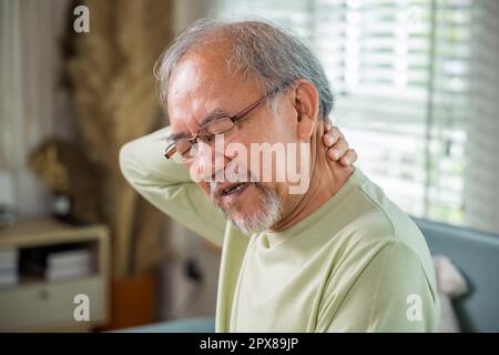 Old man suffering from nape neck pain at home, Elderly acute neckaches, Sad senior man neckache hand holding neck, Old age retirement health problems Stock Photo