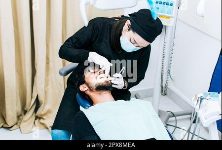 Dentist performing dental checkup, dentist checking braces to patient, patient checked by dentist Stock Photo