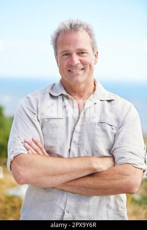 Enjoying some fresh sea air. Portrait of a mature man smiling happily at the camera. Stock Photo