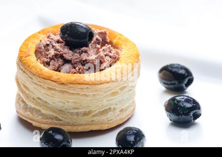 puff pastry filled with terrine served with black olives Stock Photo