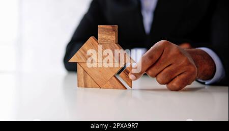 Miniature House Puzzle Pieces And Tangram. Wooden Toy Real Estate Stock Photo