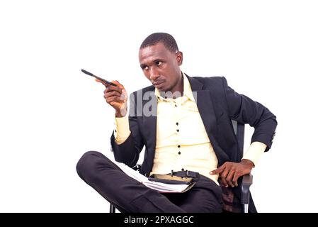 portrait of a serious businessman businessman sitting on chair and pointing pen aside. Stock Photo