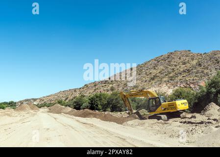 Boegoeberg Dam, South Africa - Feb 28 2023: Backhoe loaders clearing sand that blocked the irrigation canal near the Boegoeberg Dam Stock Photo