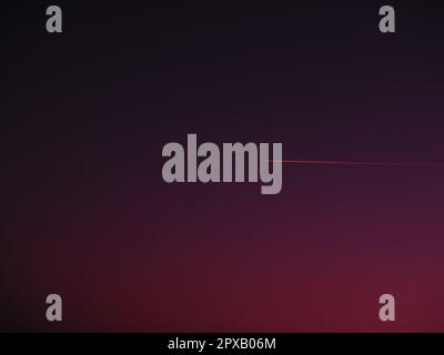 the plane and the trail in the crimson-burgundy sky. Abstract background on space or aero theme. Stock Photo