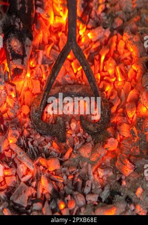 Heating branding iron for cattle over embers. Selective focus Stock Photo