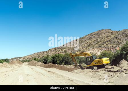 Boegoeberg Dam, South Africa - Feb 28 2023: Backhoe loaders clearing sand that blocked the irrigation canal near the Boegoeberg Dam Stock Photo