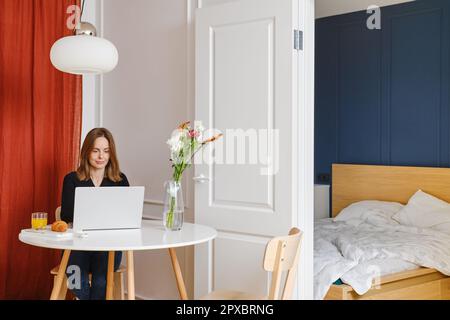 Woman working remotely from home. Freelancer or digital nomad everyday routine. Stock Photo