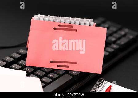 Colored sticker lying on keyboard. Important message written over paper. Stock Photo