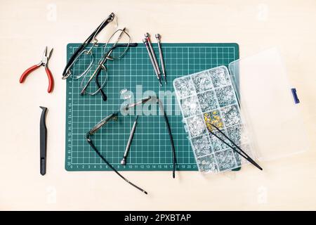 top view of kit for repairing used eyeglasses on wooden table Stock Photo