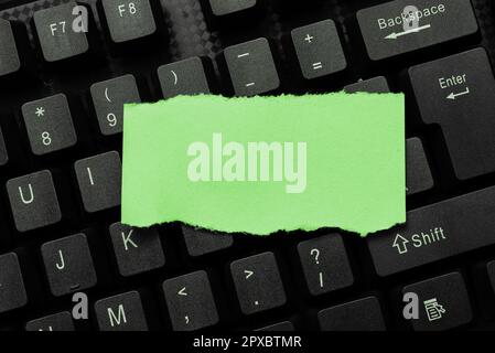 Colored sticker lying on keyboard. Important message written over paper. Stock Photo