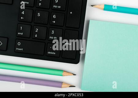Paper with important text near keyboard. Information written on notebook. Stock Photo