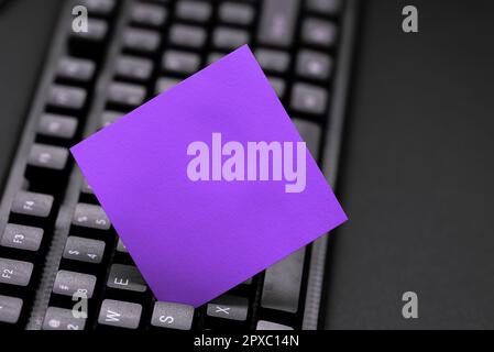 Colored sticker lying on keyboard. Important message written over paper. Stock Photo