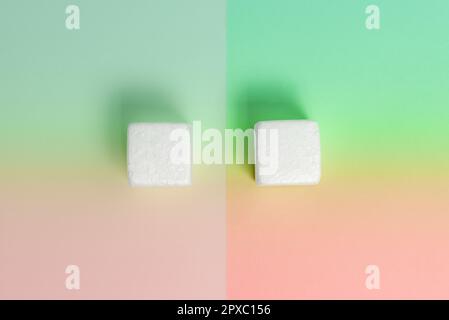 White Styrofoam Cubes Lying on Coloured Desk. Brand new Information. Stock Photo