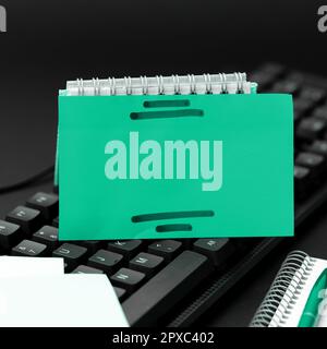 Sticker lying on black keyboard. Important message written over paper. Stock Photo