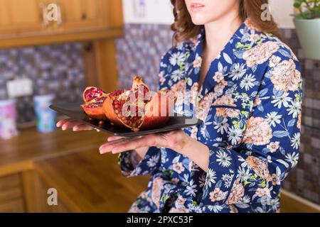 Woman holds fresh ripe pomegranate. Fruit , vitamins and food. Stock Photo