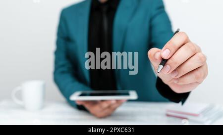 Man in jacket sitting at white table And Pointing With Pen On Message. Stock Photo