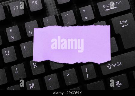 Colored sticker lying on keyboard. Important message written over paper. Stock Photo