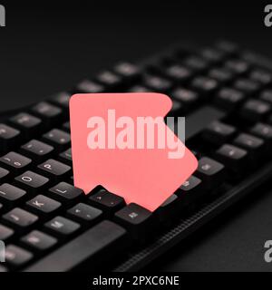 Sticker lying on black keyboard. Important message written over paper. Stock Photo