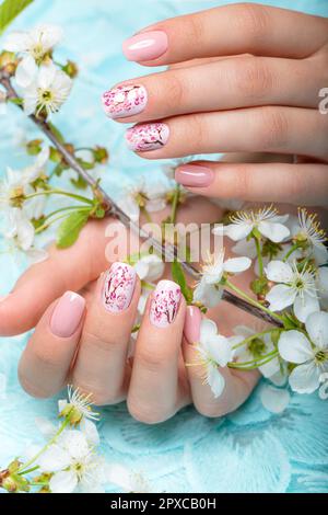 Spring manicure for the bride in gentle tones with flowers. Nail Design. Stock Photo