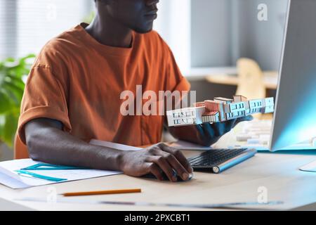 African American young engineer using computer to develop new construction project at his workplace Stock Photo