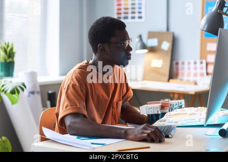 African American young architect sitting at his workplace and working on computer in office Stock Photo