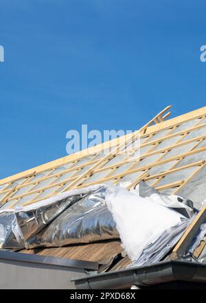 House thermal insulation with mineral wool, roof insulation technique. construction old roof from house blue sky Stock Photo