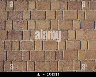 Colorful Pavement. Rectangular and square tiles in a warm brown shade under oblique evening lighting. Paving stones in Kerch. Stone background. Stock Photo