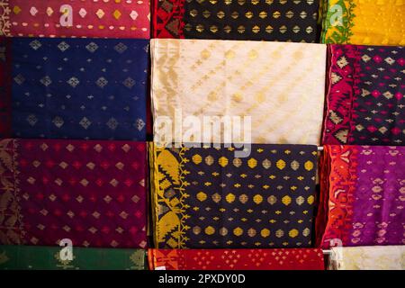 Bangladeshi Women,s Traditional Colorful Jamdani saree hanging in the retail Showrooms. Colorful Jamdani Saree Texture Background Stock Photo