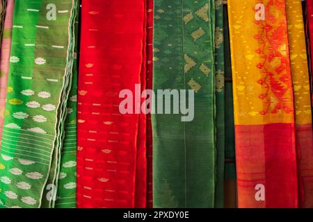 Bangladeshi Women,s Traditional Colorful Jamdani saree hanging in the retail Showrooms. Colorful Jamdani Saree Texture Background Stock Photo