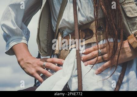 Close up courageous woman with arms akimbo concept photo. Pirate girl with dreads. Front view photography with blurred background. High quality pictur Stock Photo