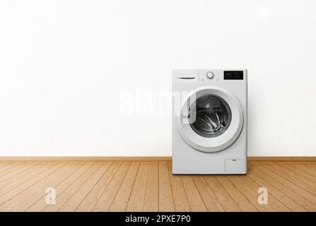 Washing machine in empty interior room. Stock Photo
