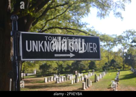 A black and white sign 'Tomb of the Unknown Soldier' placed next to a line of graves in a cemetery setting Stock Photo