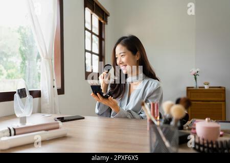 Beauty blogger using brush with powder to applying product for reviewing cosmetic in makeup vlogger. Stock Photo