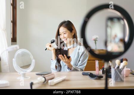 Beauty blogger use brush with blush on to applying product for reviewing cosmetic in makeup vlogger. Stock Photo
